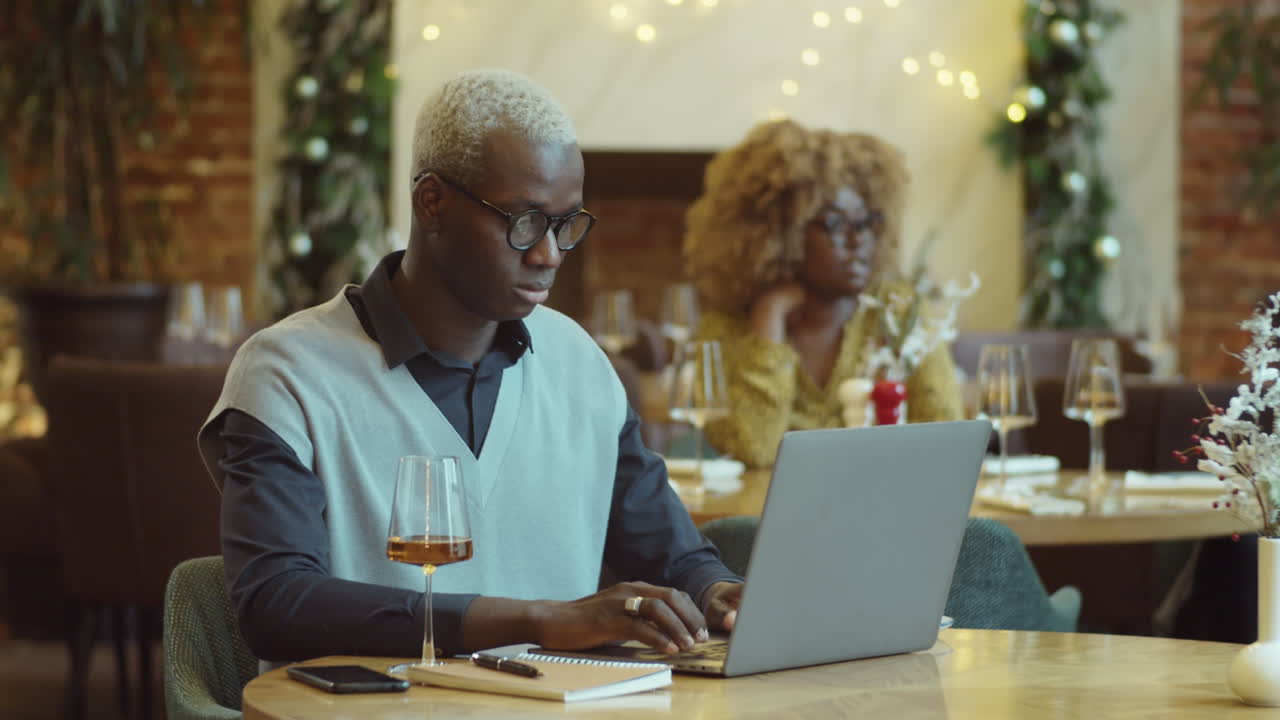 African American Man Working on Laptop in Cafe