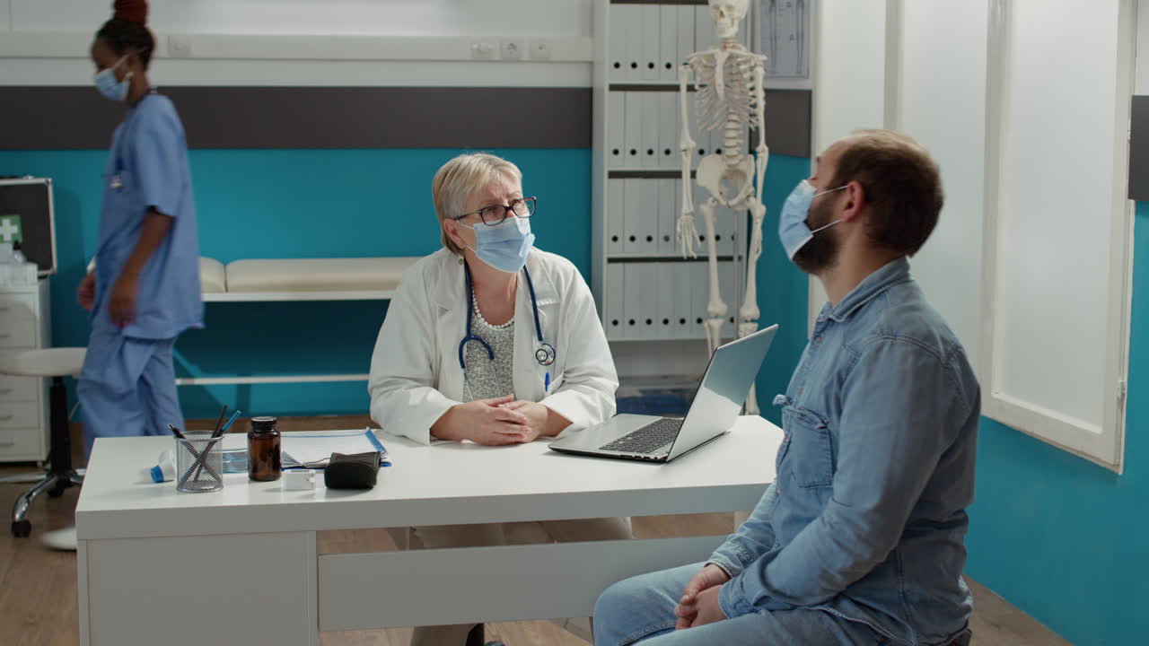 Physician and male patient having conversation at medical examination