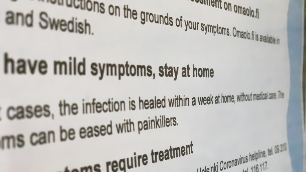 COVID-19 paper on a information glass, at a health care station - Corona virus infected person with mild symptoms, stay at home - handheld view