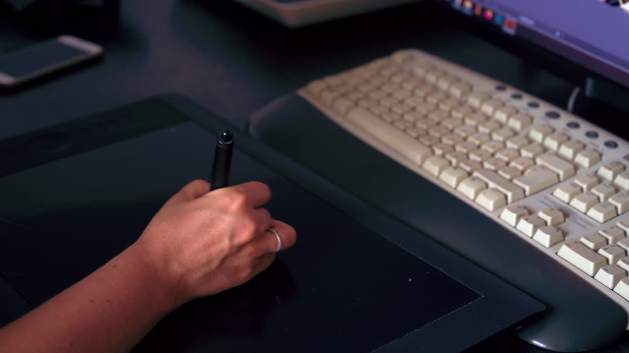 Donna che progetta su uno schermo a un tavolo davanti a un PC
