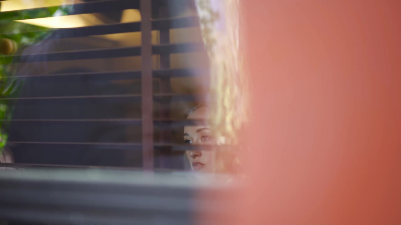 una mujer mirando por la ventana.