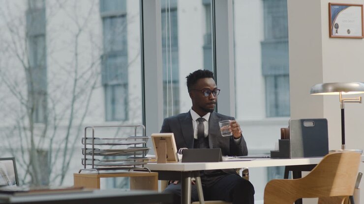 Young man drinking water on his desk