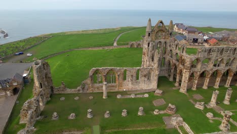 ruines de l'abbaye de whitby entourées de vertes prairies avec la mer en arrière-plan, dans le yorkshire au royaume-uni