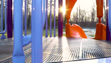 Left-to-right-pan-of-playground-equipment-with-sun-burst-in-background