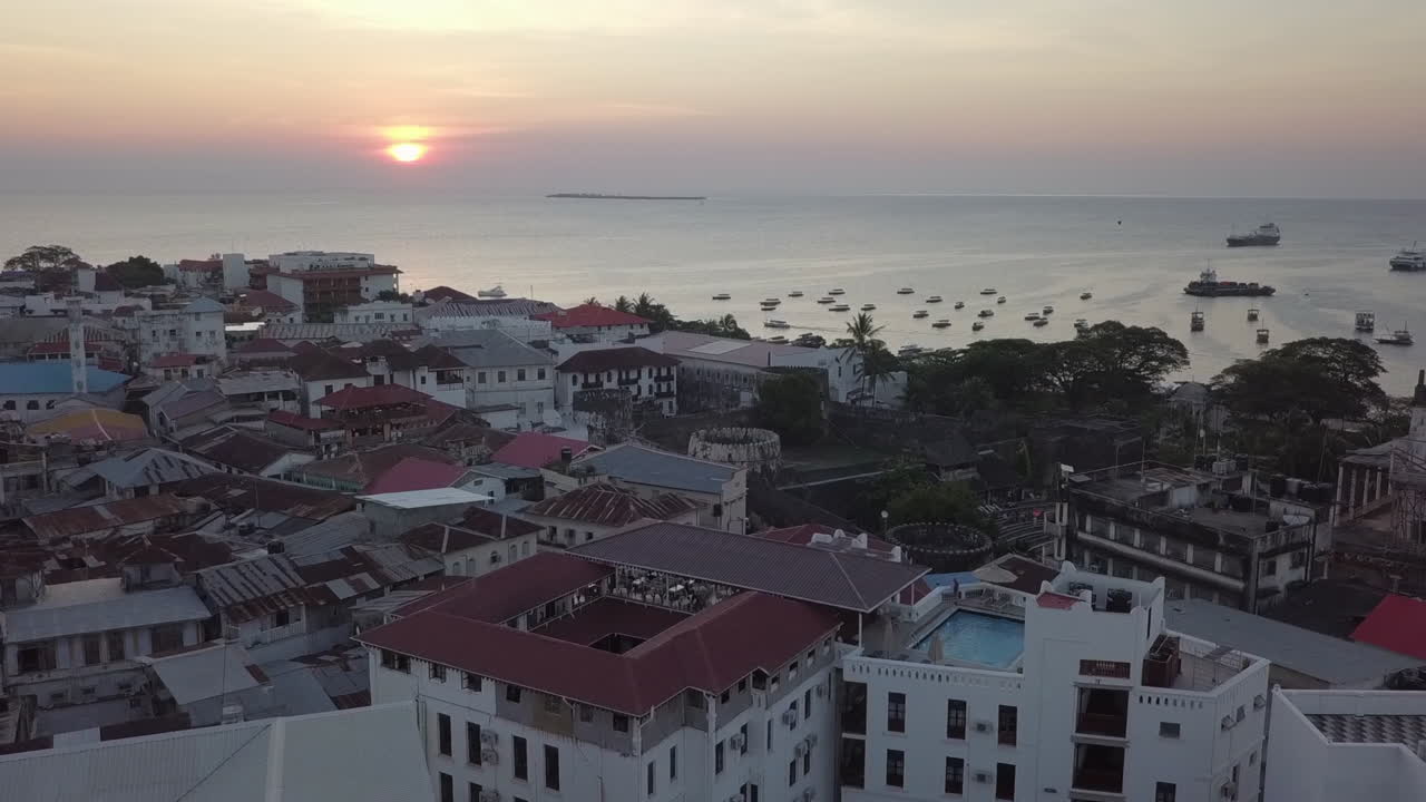 Volo aereo al tramonto verso il Vecchio Forte sul lungomare storico di Zanzibar.