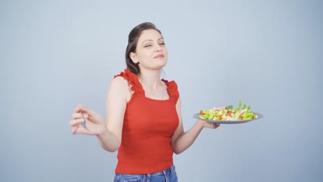 a person who diets and eats healthily. she eats salad and dances.