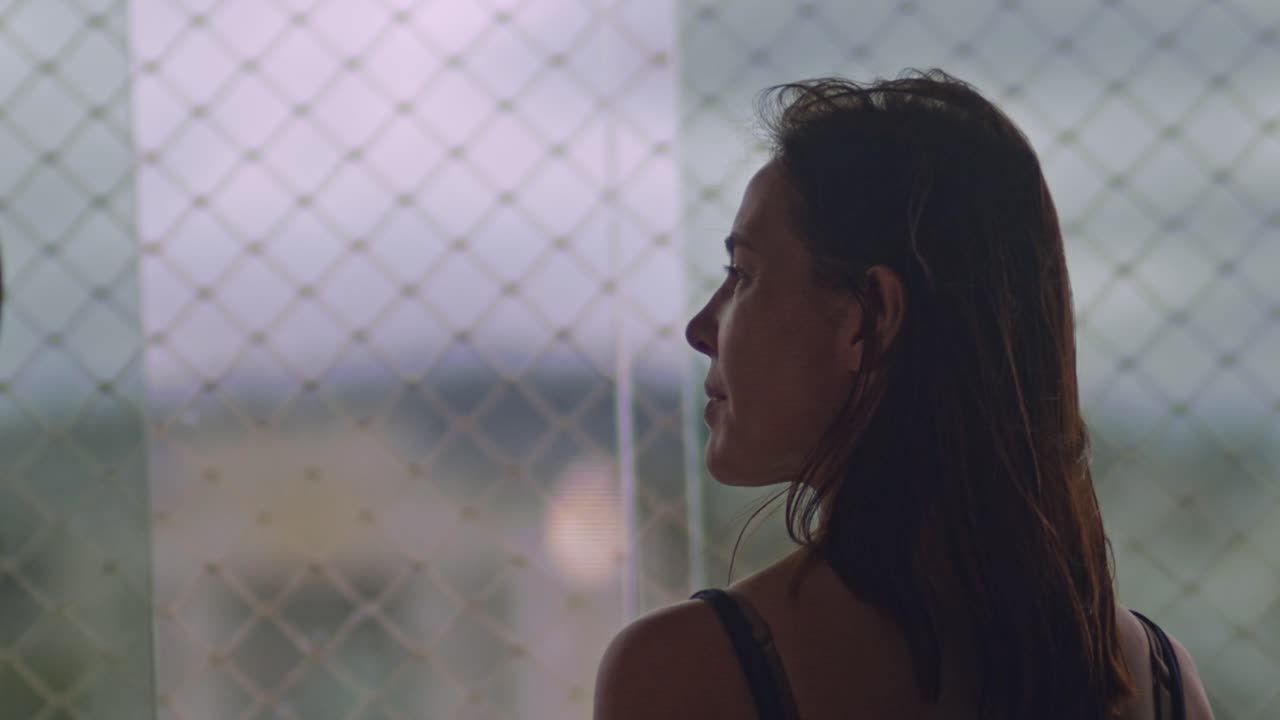 바람 부는 우울한 아침에 감탄하는 중년 갈색 머리 여자를 닫습니다