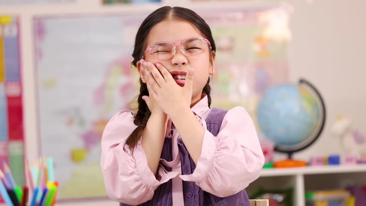 Young Girl Experiencing Toothache in Classroom
