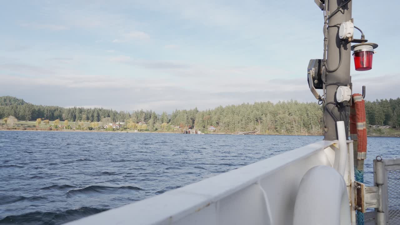 Thetis Island, Columbia Britannica, Canada: una calma distesa d'acqua riflette la luce soffusa del giorno mentre il traghetto scivola lungo una costa boschiva - Ripresa POV