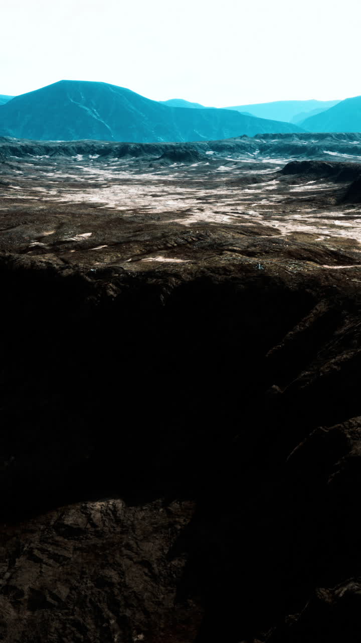 una impresionante vista aérea de un escarpado paisaje desértico con montañas en la distancia