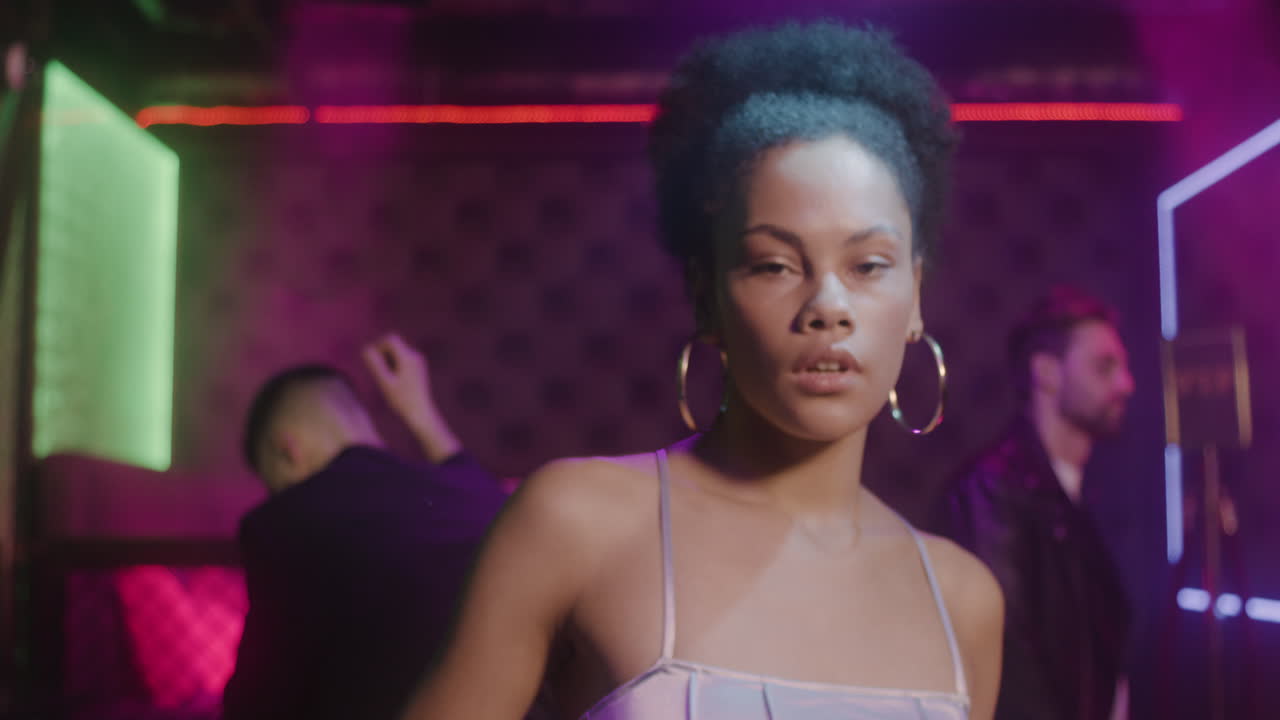 Portrait Of Beautiful Girl Looking Confident At Camera At Disco While Her Friends Dancing Behind Her 2