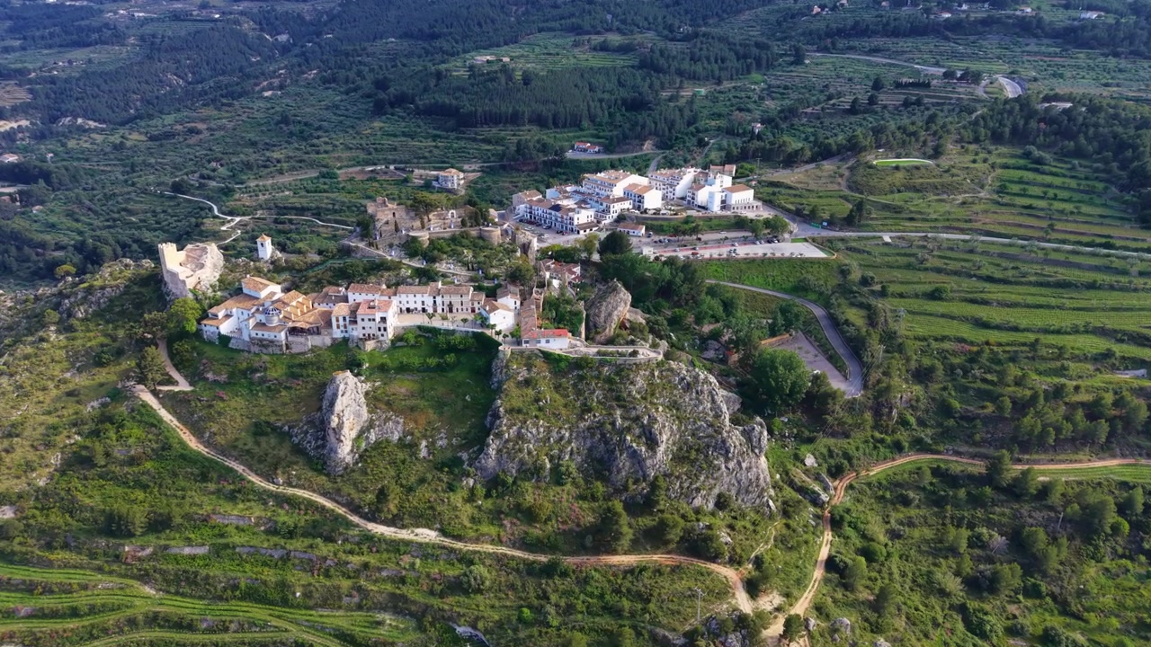 Guadalest historiske slotsby beliggende på en klippefyldt bakketop omgivet af frodige grønne dale, terrassemarker og bjerglandskab i Alicante, Spanien