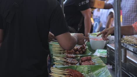 thai people buying food in a street marketplace in thailand