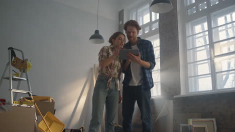 serious family studying interior ideas with tablet. couple looking to gadget.