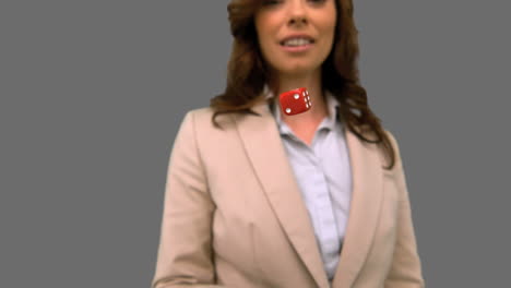mujer de negocios lanzando un dado en la pantalla gris