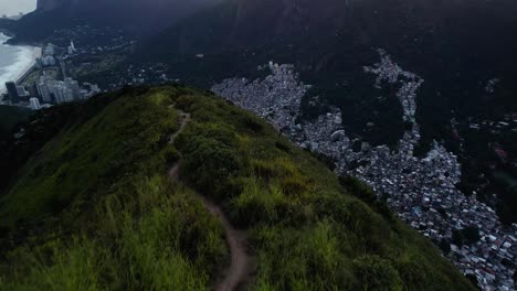 Aerial-view-tilting-over-the-Don-Irmaos-mountain,-revealing-the-favela-da-Rocinha,-sunset-in-Rio-de-Janeiro,-Brazil