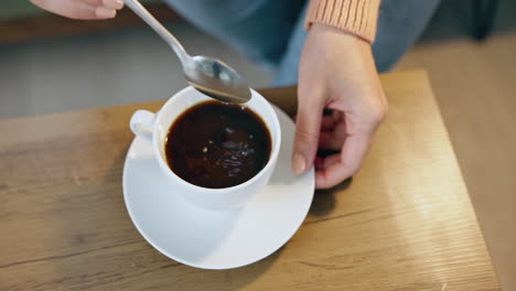 Hands-of-woman-with-coffee-on-table-from-above