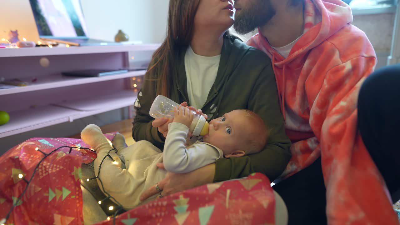 크리스마스 시즌 동안 아기에게 먹이를 주는 행복한 가족
