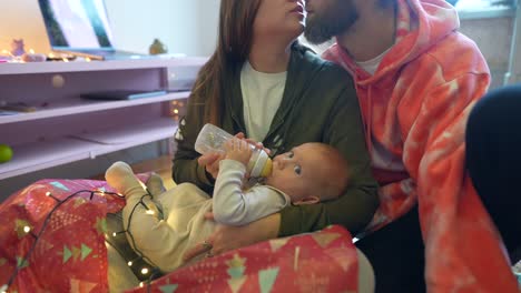 familia feliz alimentando al bebé durante la temporada de navidad
