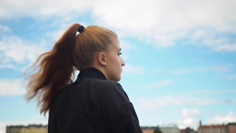 young girl staring at the view and wind blows her long hair