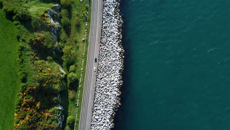 Downward-aerial-view-of-road-on-coastline-in-northern-Ireland-with-rocks