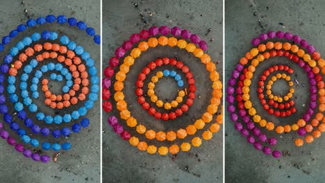 aerial view of colorful umbrella spiral arrangement on ground: vibrant patterns in blue, orange, red, and purple creating visual harmony