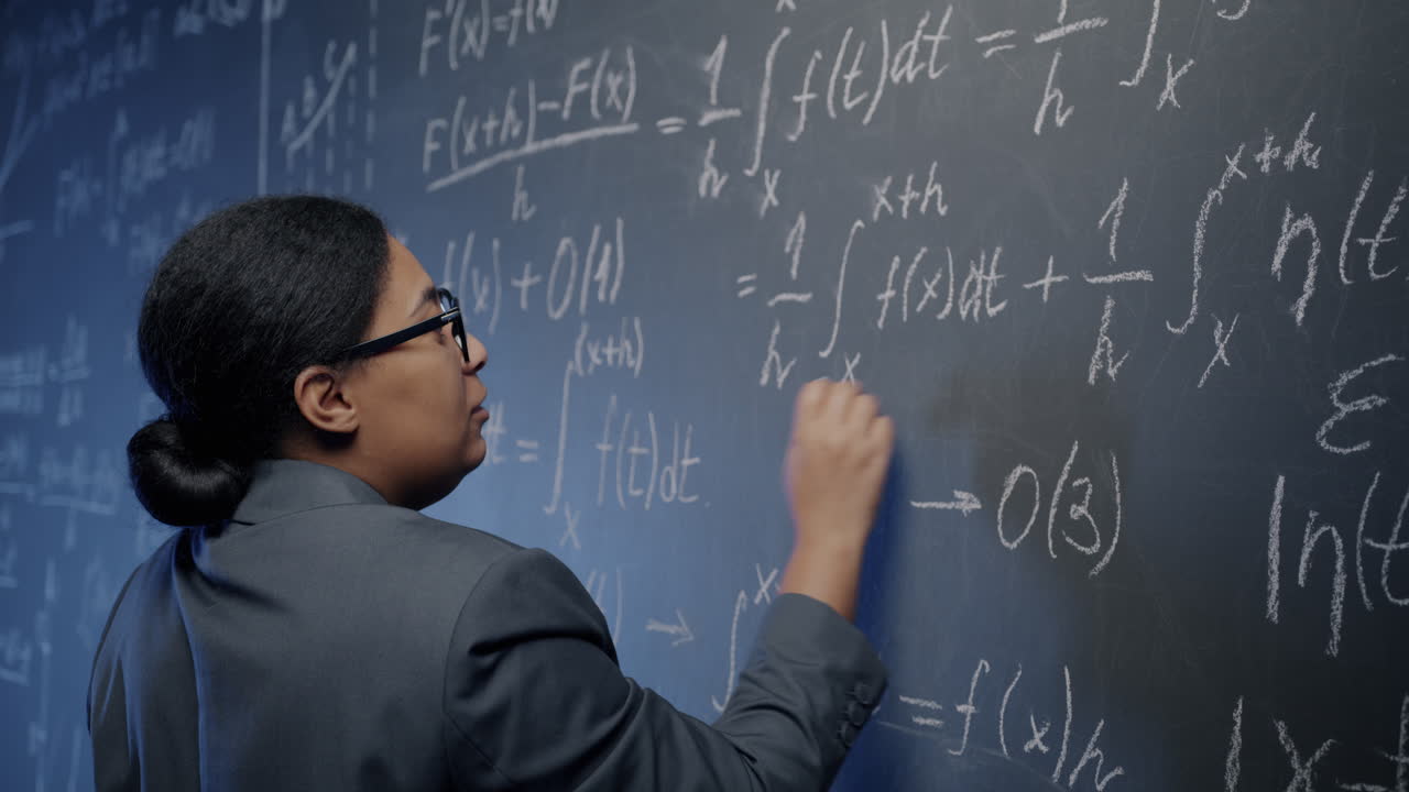 Woman Writing Equations on a Blackboard