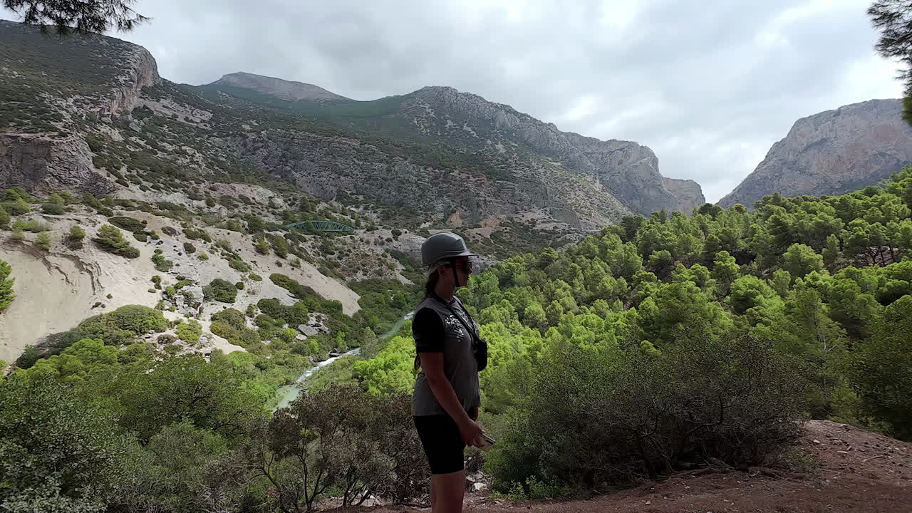 una fotografía de cerca de una mujer turista caminando a lo largo del observatorio ornitológico el cabrito en tafira, españa en un día nublado