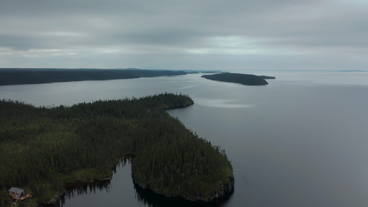 흐린 날 광활한 광야의 고립된 오두막 위로 날아가는 드론