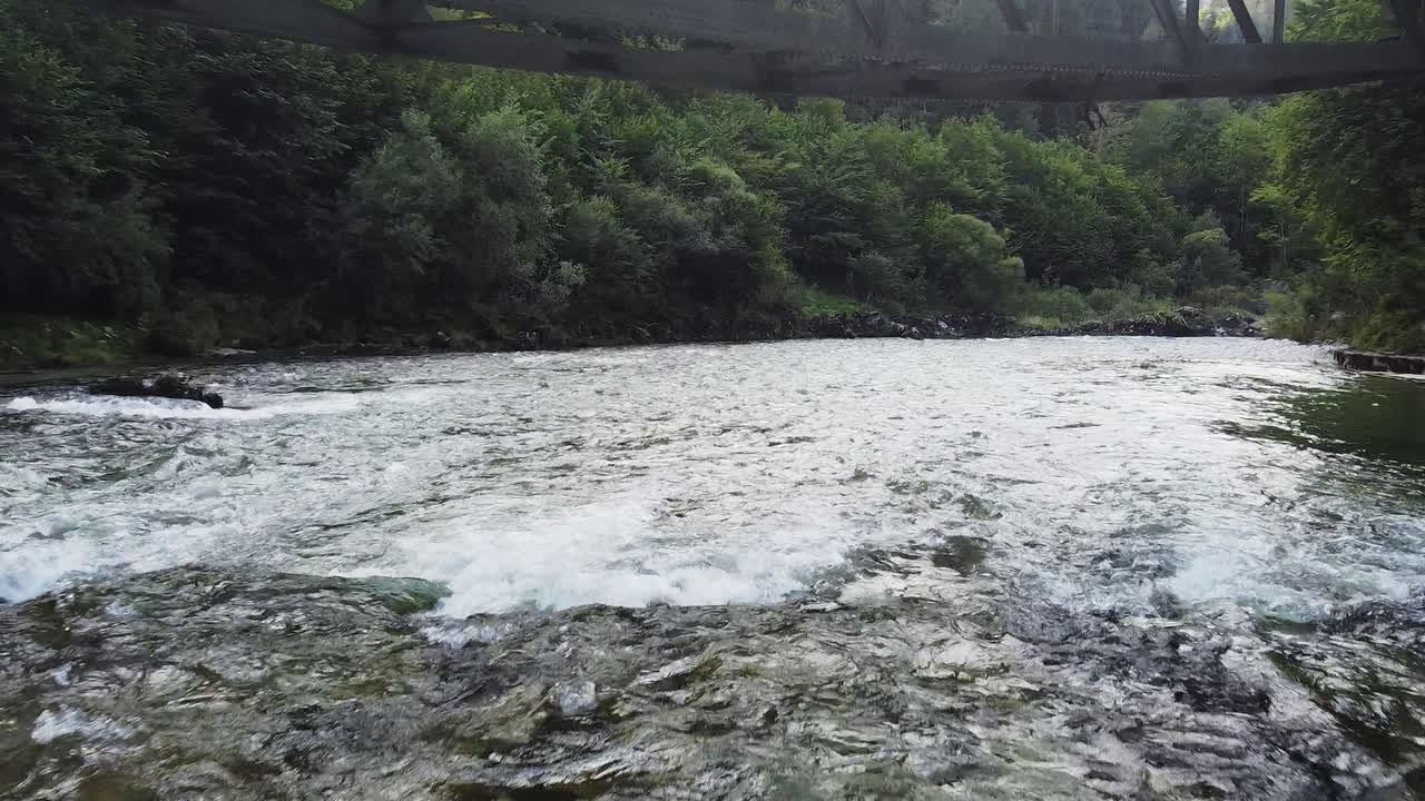 철도 다리 아래, 강바닥을 따라, 드론 비행