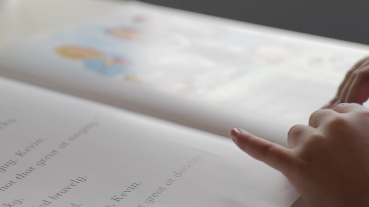 a young child reading a book, close-up soft focus