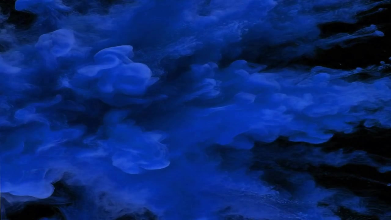 Nuvola di inchiostro blu che si diffonde nell'acqua su sfondo nero