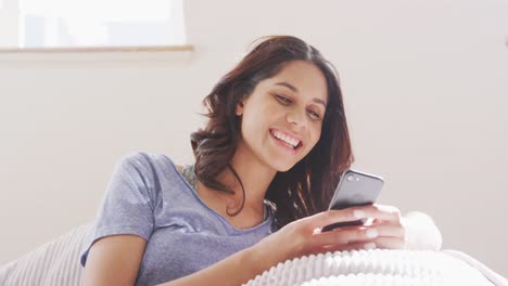 Mujer-Alegre-Ajustando-Su-Cabello-Detrás-De-Su-Oreja-Mientras-Usa-Un-Teléfono-Inteligente