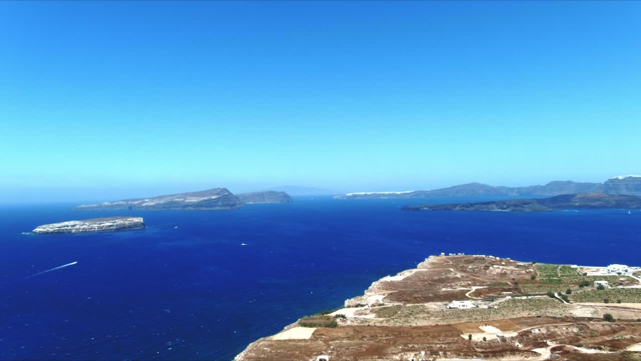 산토리니 그리스의 아크라 마브로 보노 위에 있는 동안 먼 보트의 공중 4k 푸른 바다와 하늘 꼭대기 전망