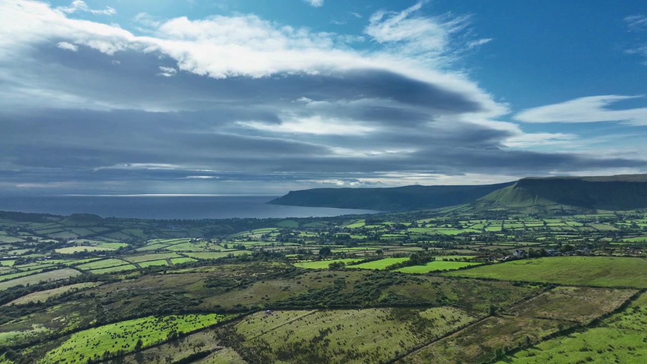 Veduta aerea sulle selvagge e aspre Glens of Antrim, Irlanda del Nord, che rivela valli verdi lussureggianti, dolci colline e uno spettacolare paesaggio costiero