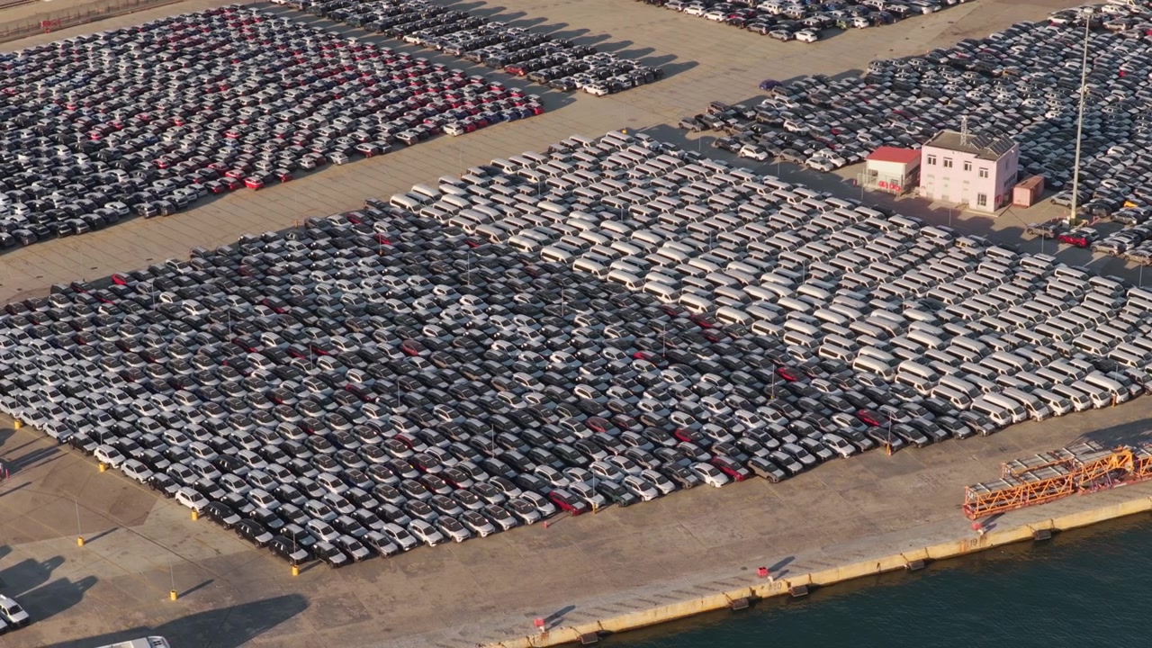 Milhares de carros novos estacionados em fileiras organizadas em um terminal portuário, aguardando exportação e importação em um enorme pátio industrial, representando a indústria automotiva global, logística e comércio