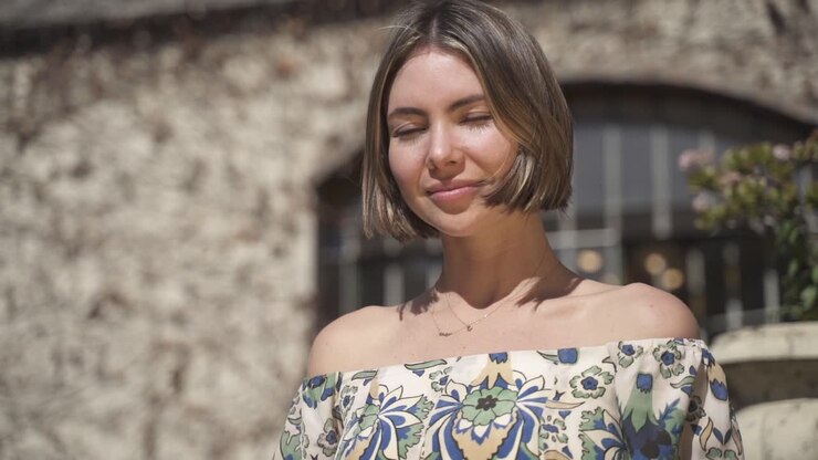 una joven de pelo muy corto sonríe a la cámara, a cámara lenta