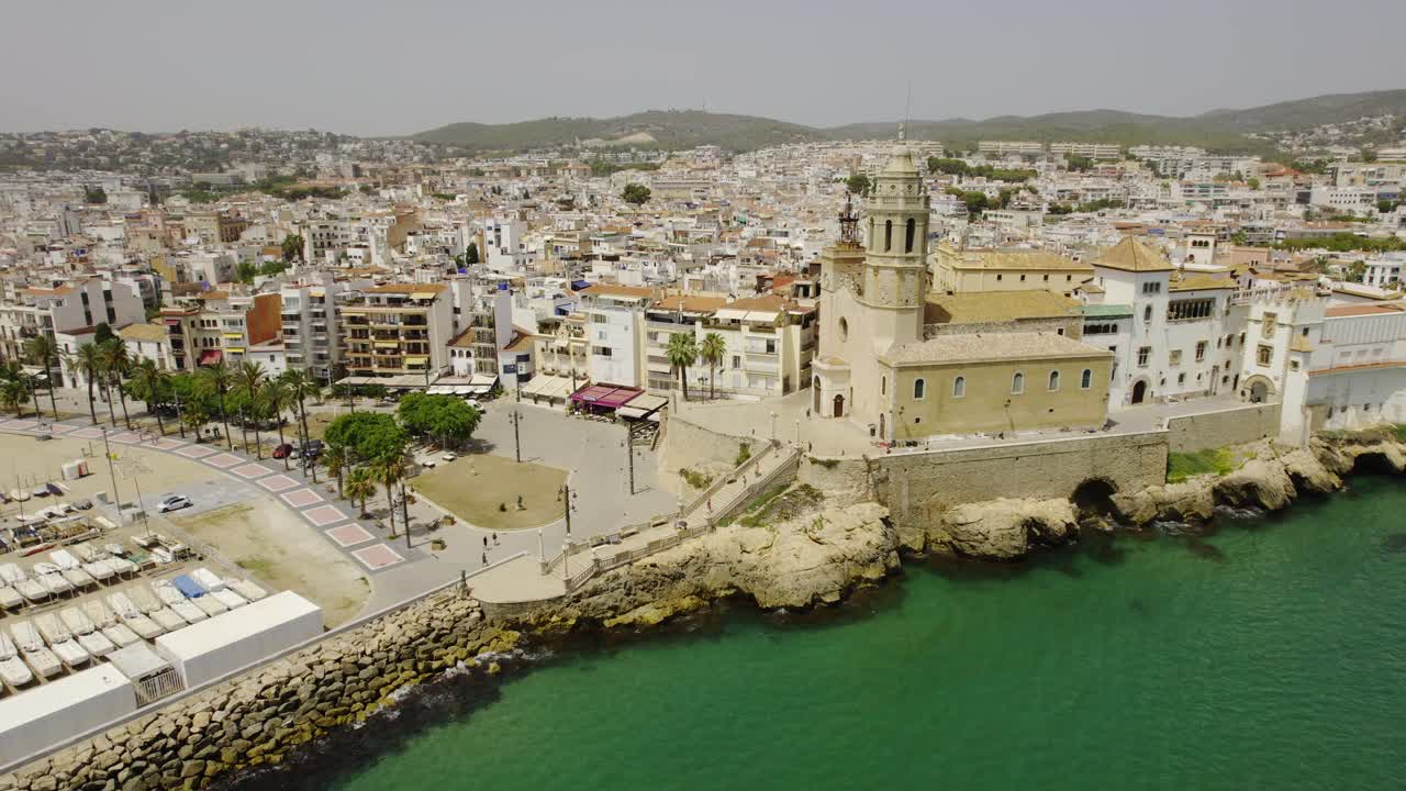 Aerial View of a Mediterranean Coastal Town with Beach, Harbor, and Historic Church