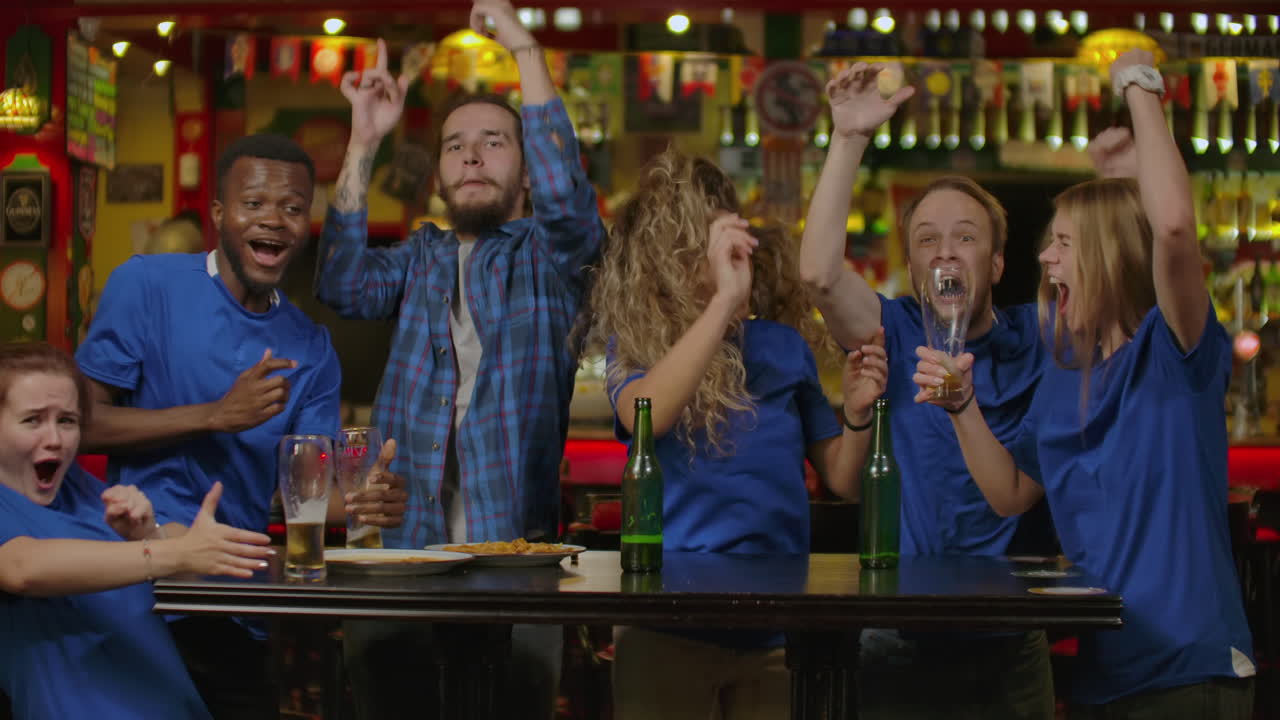 amigos o aficionados al fútbol viendo fútbol en el bar