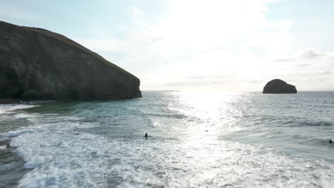 Playa-De-Trebarwith,-Cornualles,-Vuelo-Aéreo-A-Través-Del-Hermoso-Mar-Hacia-La-Luz-Del-Sol-Hasta-Los-Acantilados-Del-Promontorio---Mavic-3-Cine-Prores-422---Clip-2