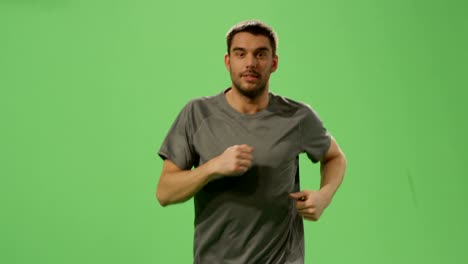 man in a t-shirt is jogging on a mock-up green screen in the background.