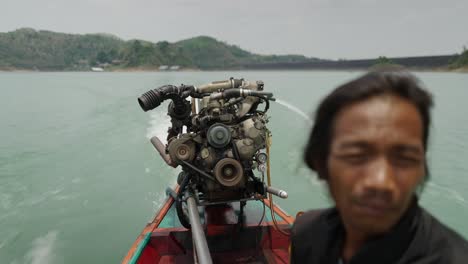 longtail boat journey on a lake with a visible engine and operator