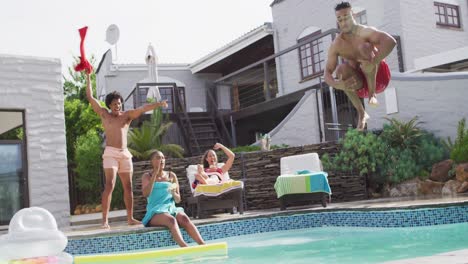 hombre latino saltando a la piscina y riendo con amigos en la fiesta de la piscina