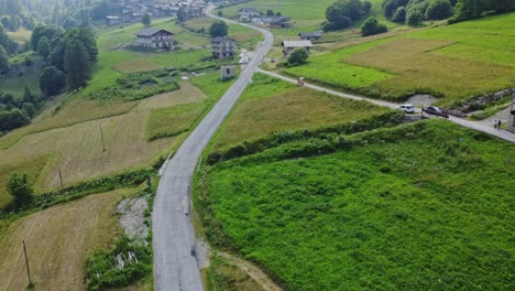 aerial view of desolate roads surrounded by green meadows in the rural region of the cotian alps, on the border of italy and france