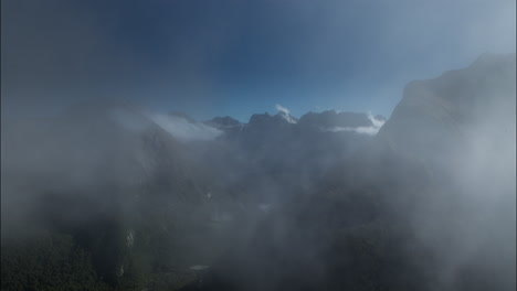 time lapse of heavy fog moving through the rugged mountains deep in fjiordland national park, new zealand