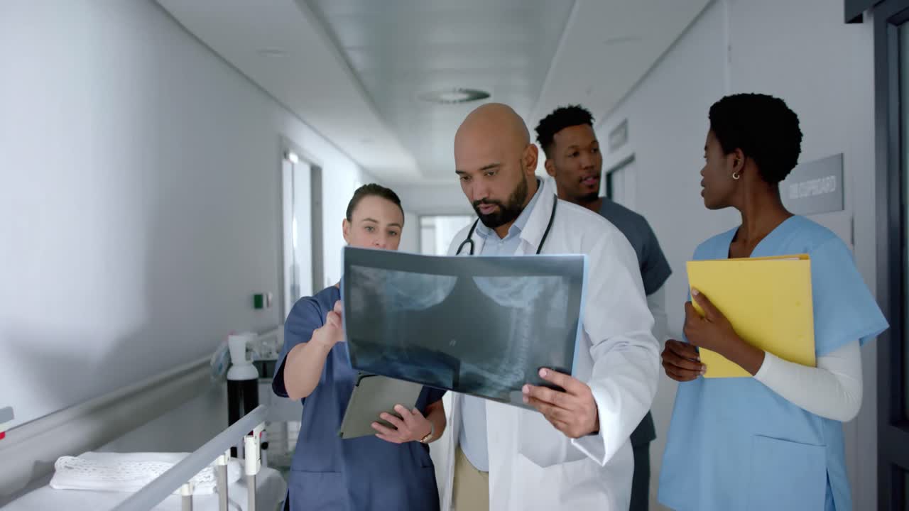 diversos médicos con escáneres de rayos x y hablando en el pasillo del hospital, en cámara lenta