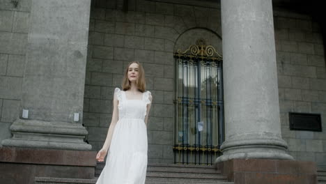 woman in white dress in front of an old building