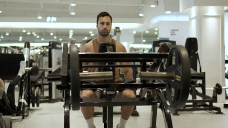 fit sporty man exercises in dips lower chest press machine at modern gym - parallax motion