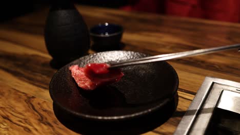 slicing and grilling meat on a yakiniku grill