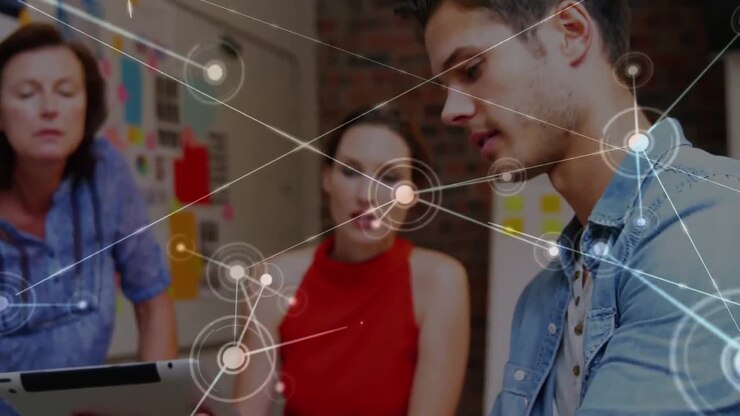 Animation of network of connections over diverse colleagues discussing over a tablet at office